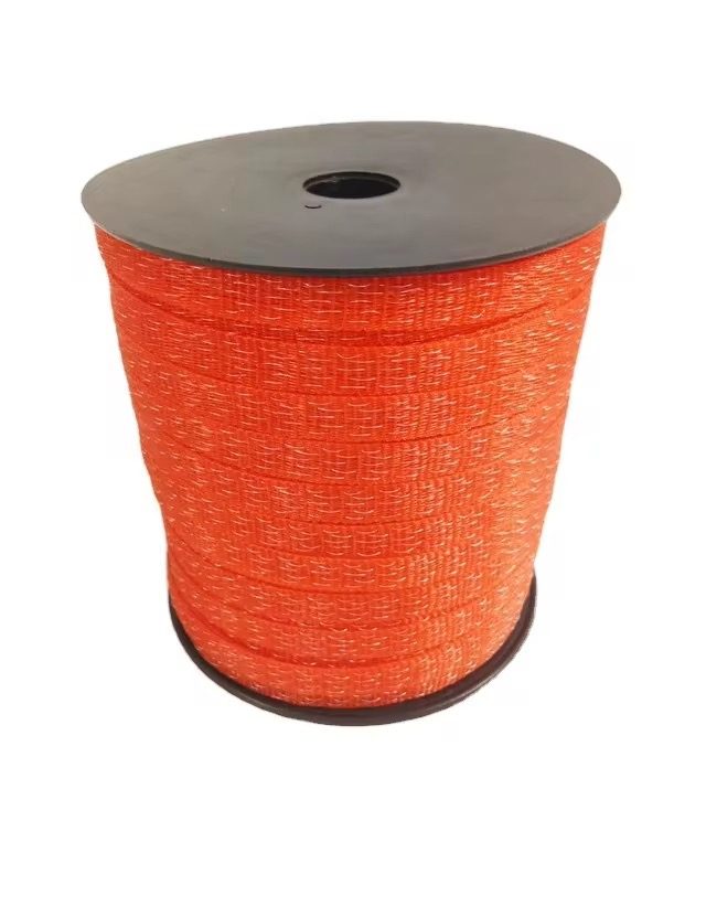 Orange electric-fence polytape with the reel cap visible, showing the wound tape stack