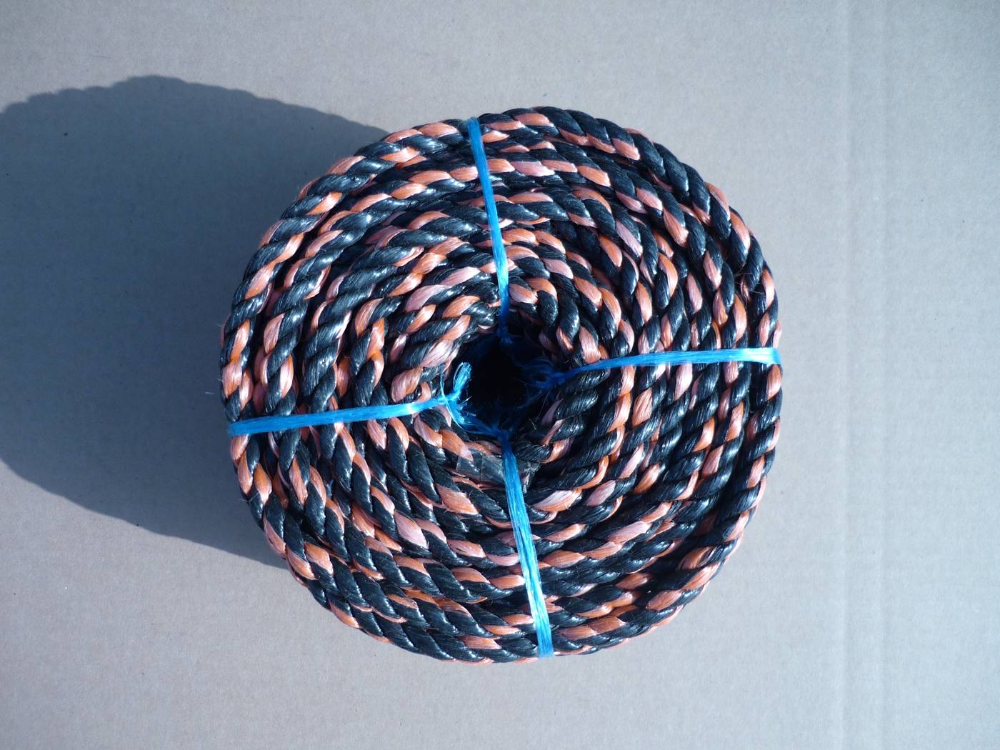 Mixed-color 3-strand twisted polyethylene / polypropylene rope, orange and black coil
